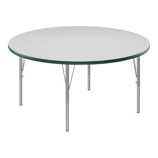 A Correll round white activity table with silver legs and green T-mold.