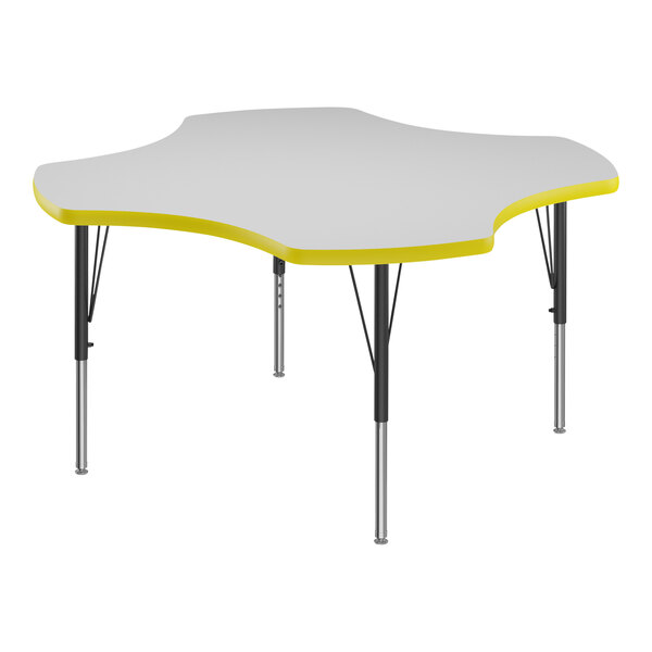 A white Correll activity table with a yellow clover-shaped top.