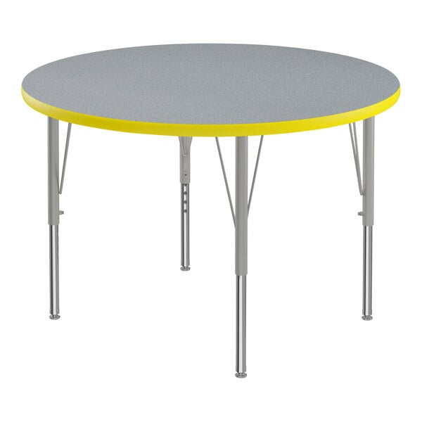 A close-up of a round Correll activity table with a gray and yellow top.