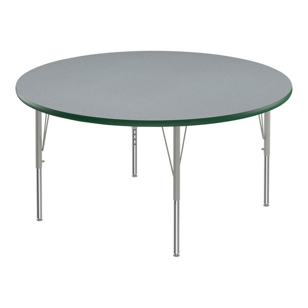 A round Correll activity table with gray top and metal legs with green edges.