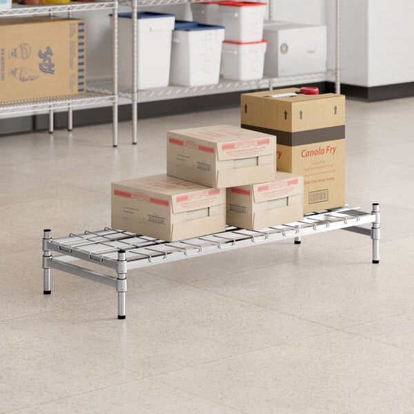 A Regency stainless steel wire rack with boxes on it.
