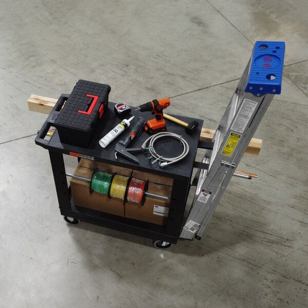 A white Luxor industrial cart with a tub shelf and flat shelf with tools on it.