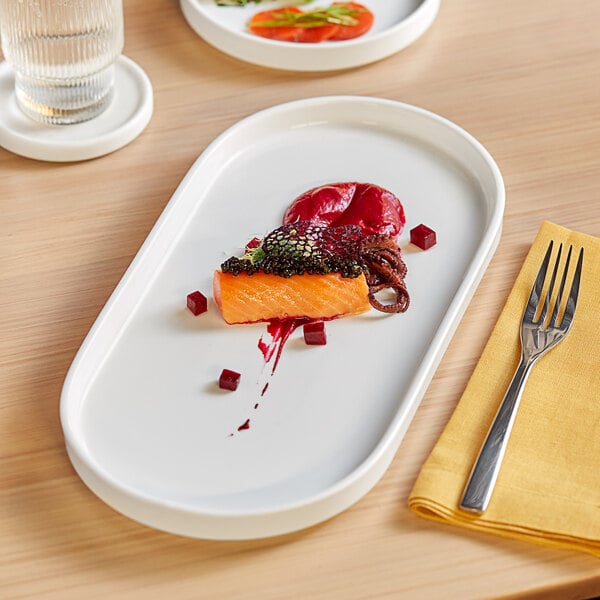 A white Acopa Lore porcelain platter with salmon and a fork on it.