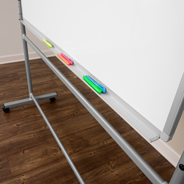 A Luxor double-sided magnetic whiteboard on a mobile stand with markers on the tray.