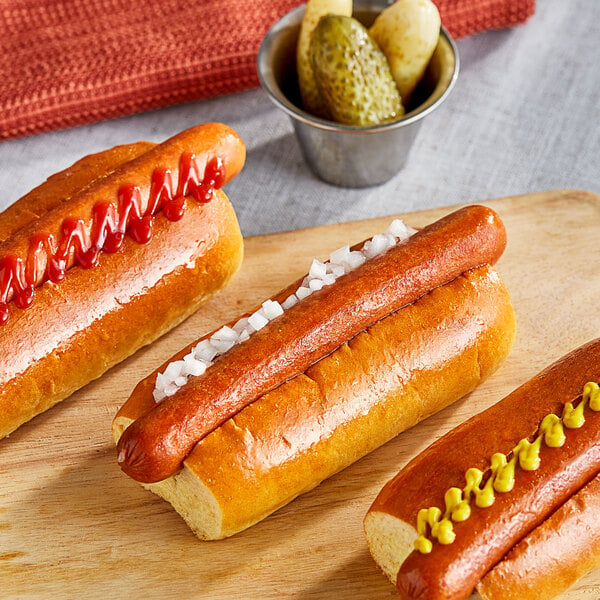 Tofurky vegan hot dogs with mustard and ketchup on a wooden board.