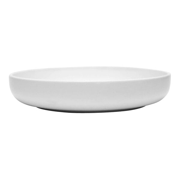 A close-up of a Libbey Driftwood satin matte porcelain low bowl on a white surface.