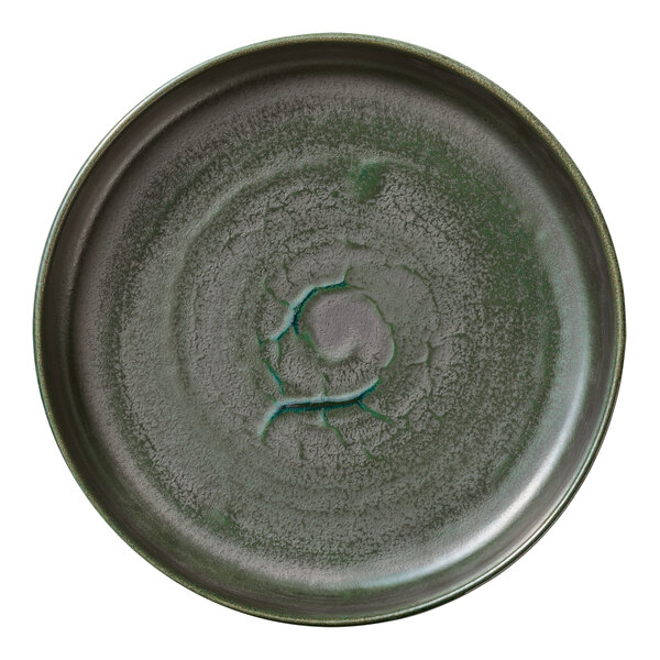 A white porcelain plate with a raised spiral design in the center and a green rim.