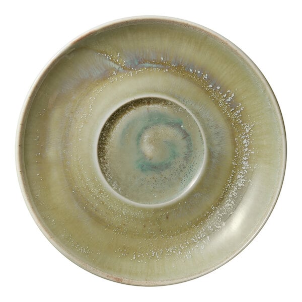 A white porcelain saucer with green swirly designs.