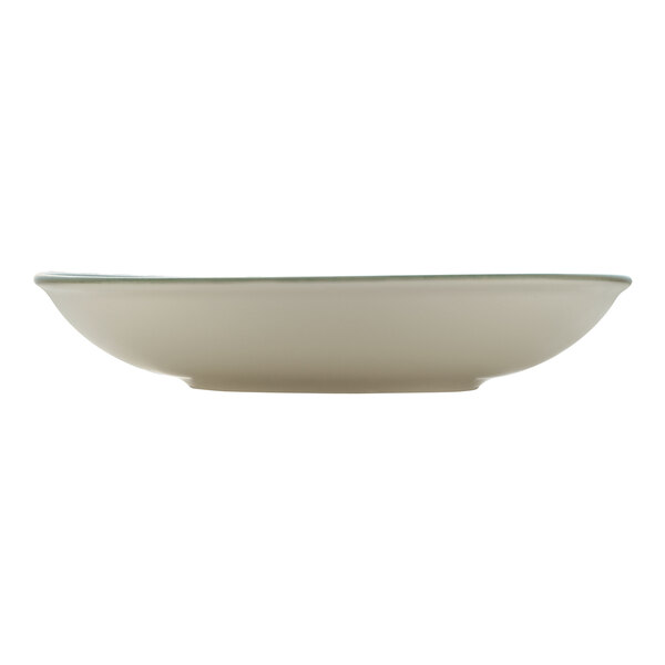 A white porcelain deep coupe plate with a green rim.
