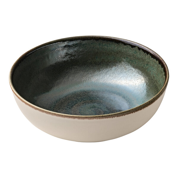 A white porcelain serving bowl with a green and blue glaze and white rim.