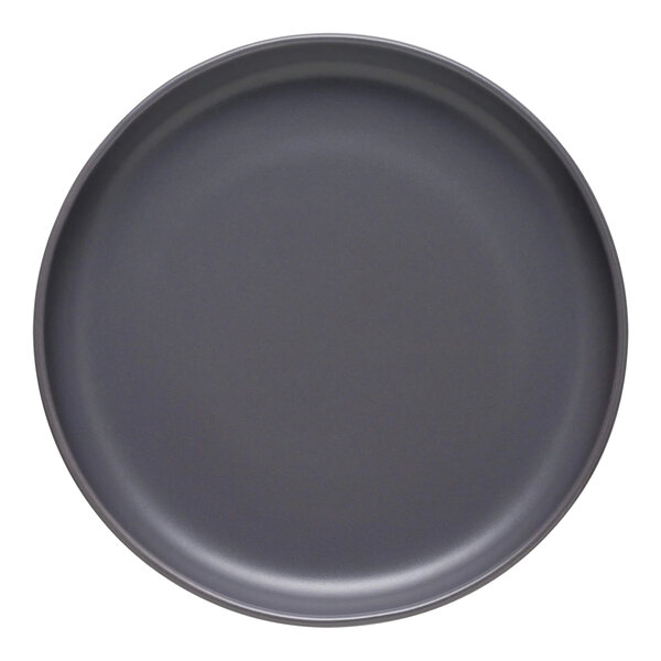 A close-up of a Libbey Driftstone granite satin matte porcelain coupe plate with a black rim.