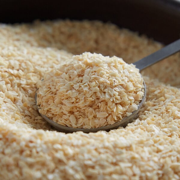 A spoon full of minced onion sits in a bowl.