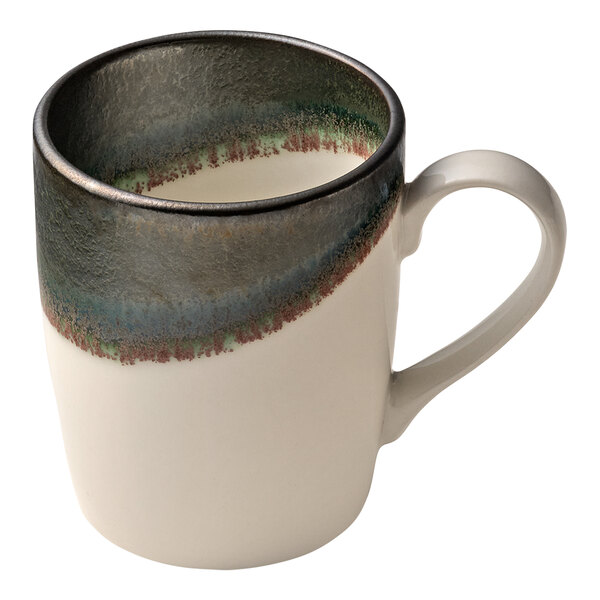 A white porcelain mug with a green and blue heart design and a handle.