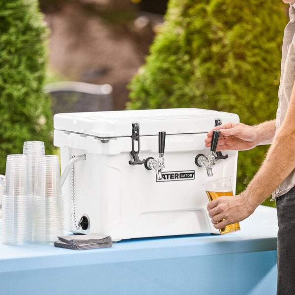 A man pouring a beer from a white CaterGator insulated jockey box.
