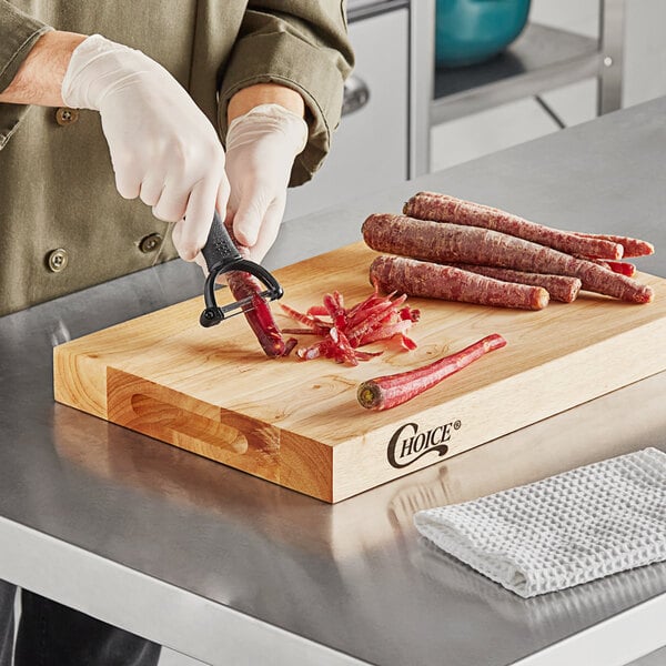 A person cutting peppers on a Choice wood cutting board.