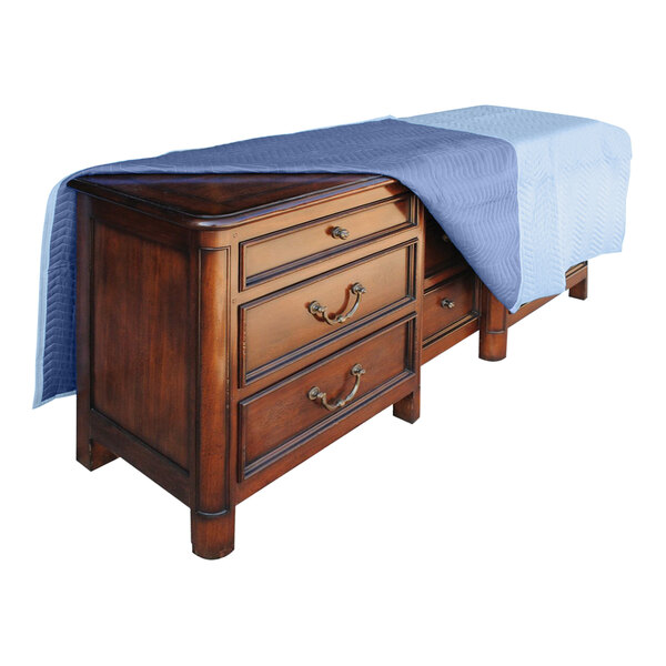 A blue Vestil moving blanket covering a wooden dresser.