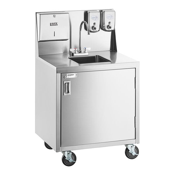A stainless steel portable hand sink cart with a single bowl, gooseneck faucet, paper towel dispenser, soap dispensers, and a cabinet on wheels.