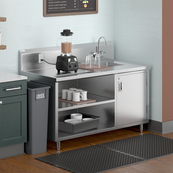 A Regency stainless steel beverage table with a sink on a kitchen counter.