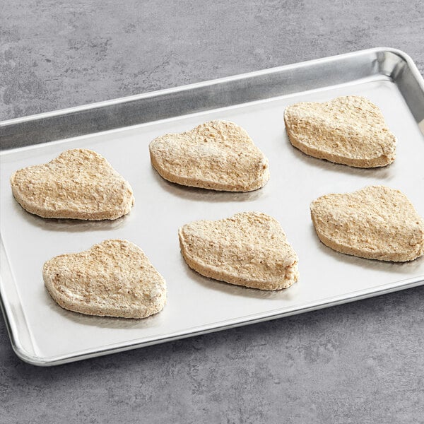 A tray of Impossible Foods plant-based chicken filets on a gray surface.