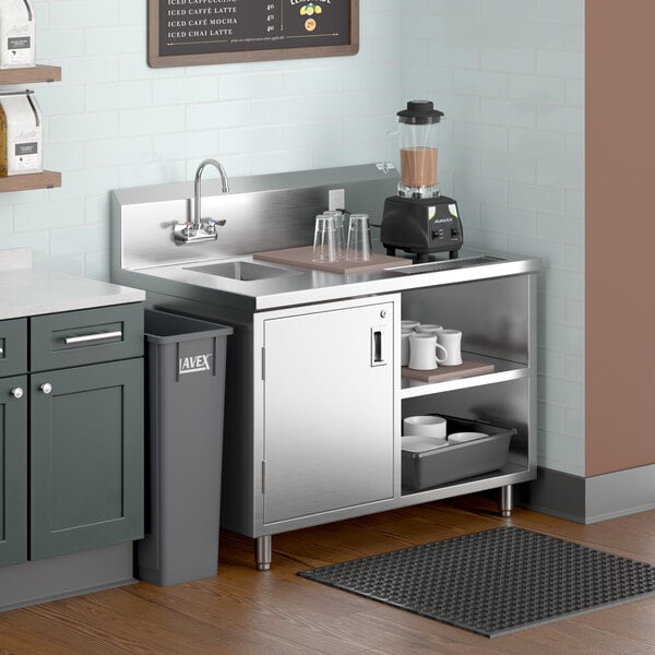 A Regency stainless steel beverage table with a sink on a counter in a kitchen.