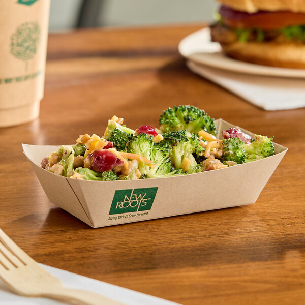 A rectangular compostable bamboo food tray filled with a broccoli salad.