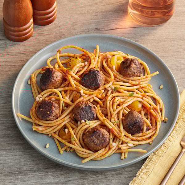 A plate of spaghetti with Impossible Foods plant-based vegan meatballs and sauce.