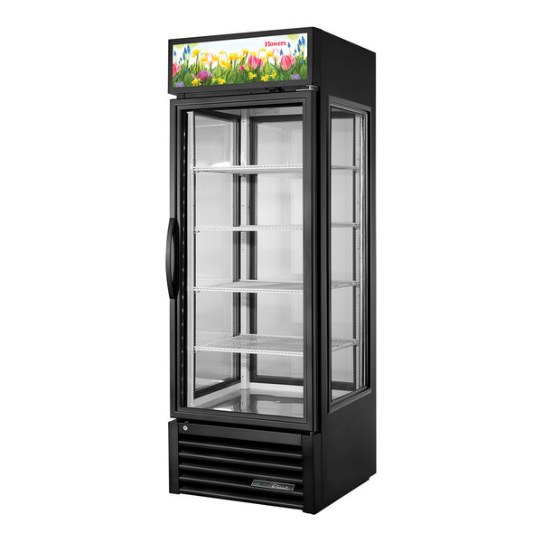 A black True refrigerated glass door floral merchandiser with a colorful display.