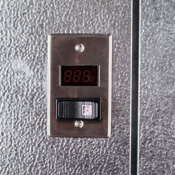 A digital temperature control panel mounted on the exterior of a walk-in cooler.