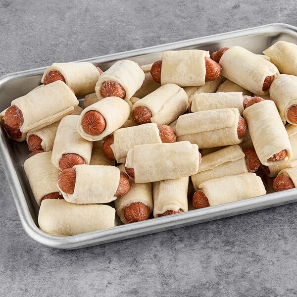 A tray of Cuisine Innovations cocktail franks wrapped in dough.
