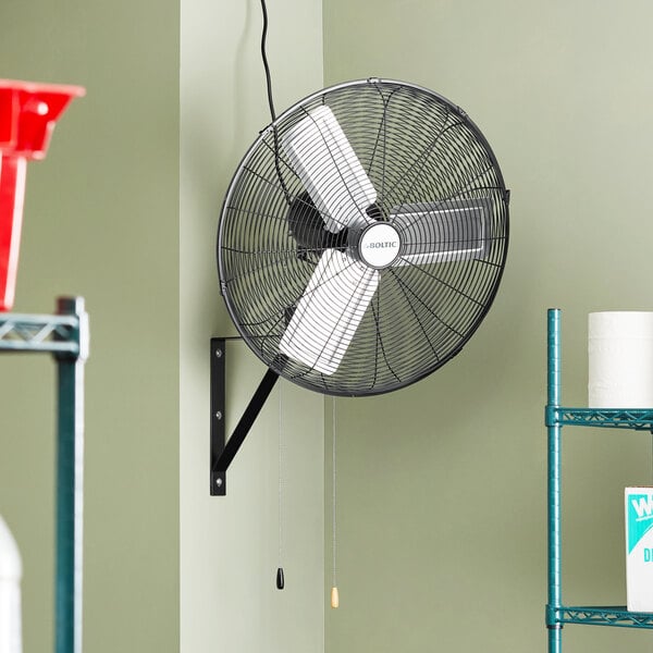 A Boltic 24" wall-mounted oscillating fan on a wall.