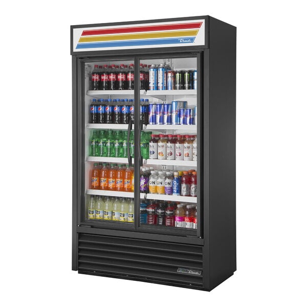 A black True refrigerated glass door merchandiser full of drinks.