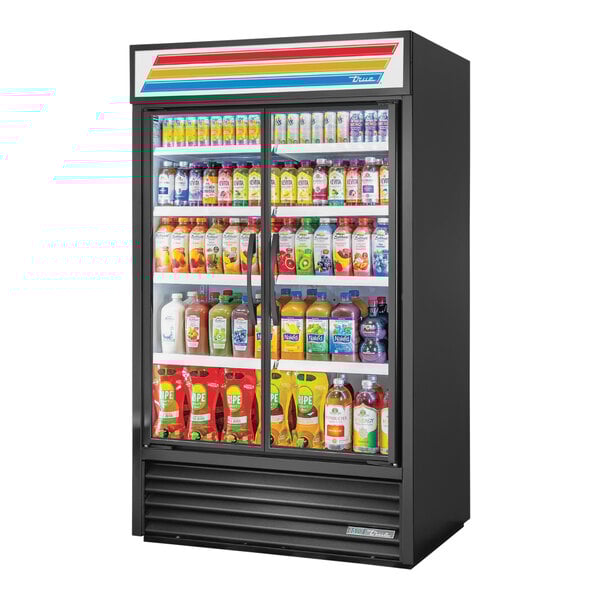 A True black refrigerated glass door merchandiser filled with drinks and beverages.