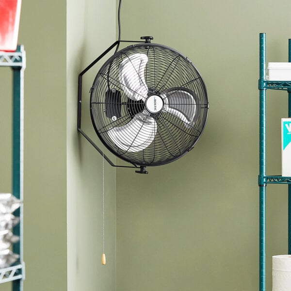 A Boltic wall-mounted fan hanging on a wall.