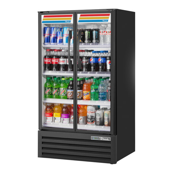 A True black narrow refrigerated glass door merchandiser full of drinks.