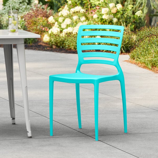 A blue resin chair on a patio.