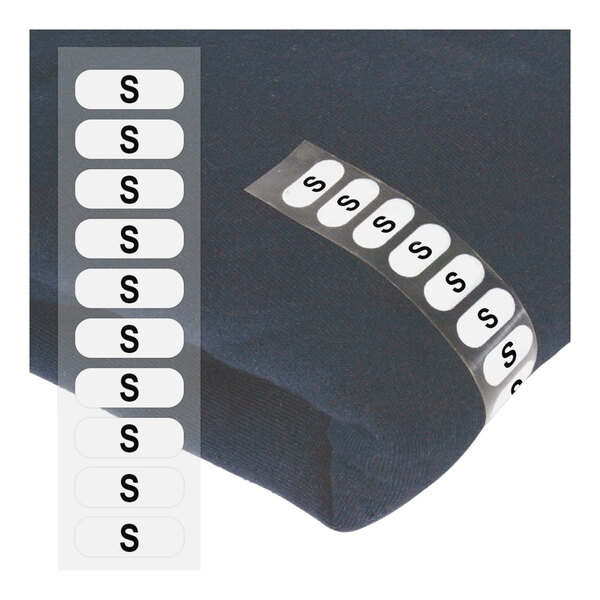 A close-up of a black sweater with a white wraparound clothing label.