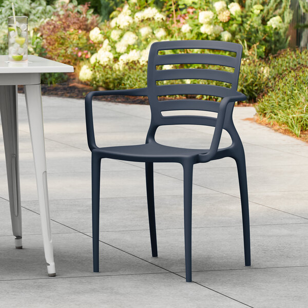 A blue resin arm chair with a slatted backrest, designed for outdoor use.
