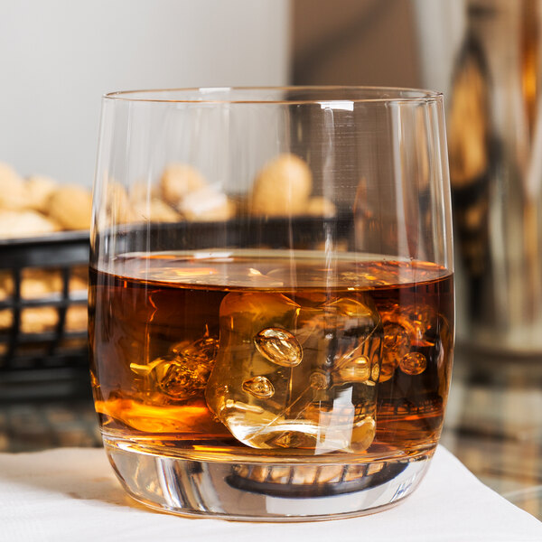 A Stolzle Weinland Rocks glass filled with liquid and ice on a table.