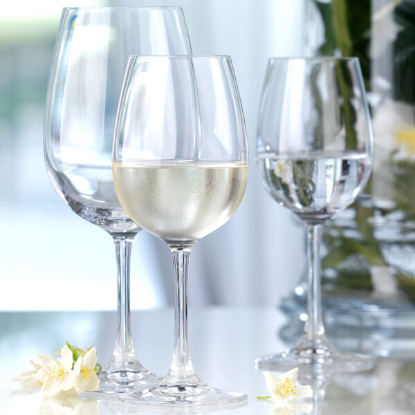 Three Stolzle Bordeaux wine glasses filled with white wine.