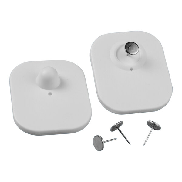 A pair of white plastic pins with a metal button on each one.