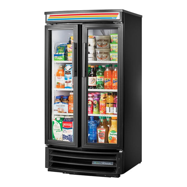 A True black refrigerated glass door merchandiser full of drinks with LED lighting.