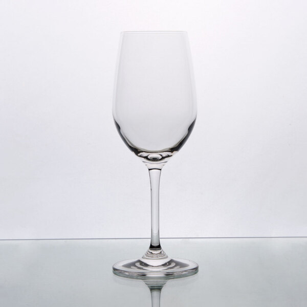 A clear Stolzle Chardonnay wine glass on a reflective surface.