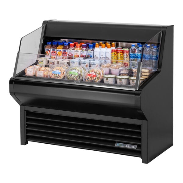 A black True refrigerated air curtain merchandiser on a counter with food inside.