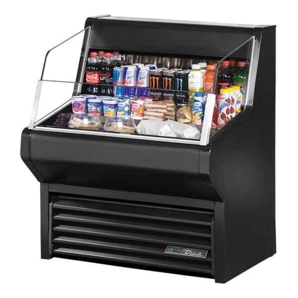 A black True refrigerated air curtain merchandiser on a counter with drinks and beverages.