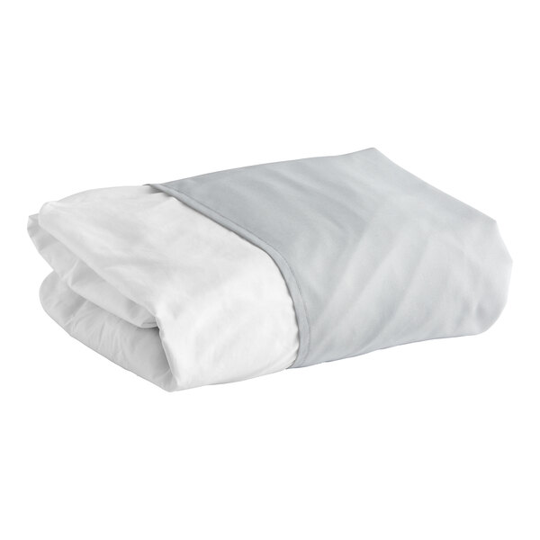 A folded 1888 Mills grey bed skirt with white and grey sheets.