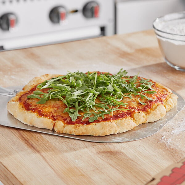 A pizza with Caputo Fioreglut gluten-free flour crust and green leaves on top.