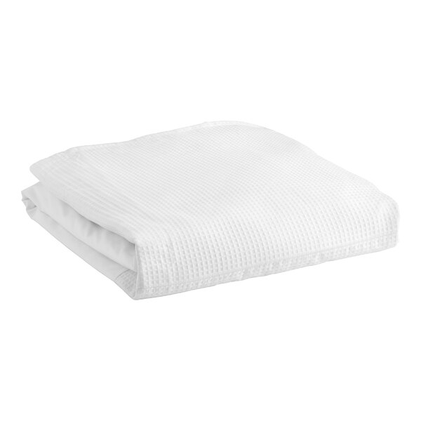 A white bed skirt folded on a white surface.