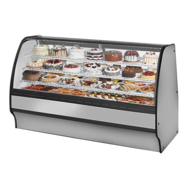 A True refrigerated bakery display case with different cakes inside.