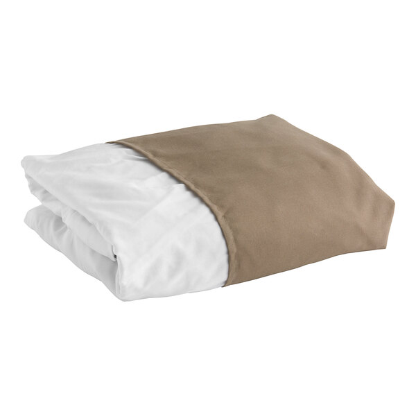 A folded beige bed skirt with white and brown sheets underneath.