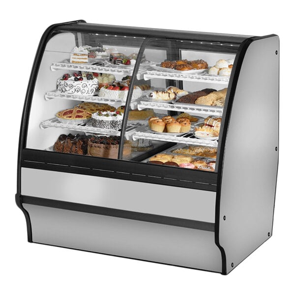 A True dual zone bakery display case with curved glass shelves holding various pastries.